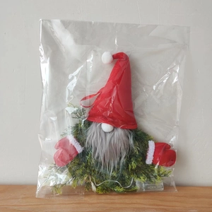 Close-up of a glowing Christmas gnome wreath with LED battery box in packaging