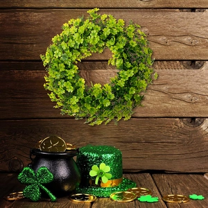Close-up of Saint Patrick's Day clover wreath on wood background with holiday props