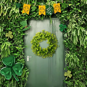 Detail of a green artificial clover wreath hanging on a door for St. Patrick's Day decor