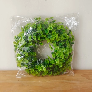 Close-up of artificial green leaf wreath for St. Patrick's Day in transparent packaging