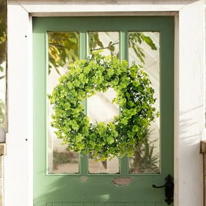 Lush green clover wreath for St. Patrick's Day decor on a vintage wooden door