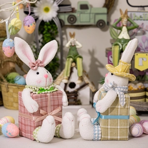 Detail of Easter plush bunnies with festive hats and checkered gift box bases decor