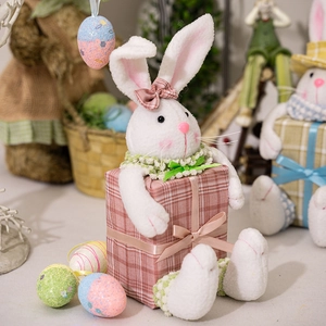 Detailed view of a plush Easter bunny with pink plaid bow holding a matching gift box