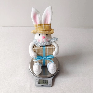 Detailed view of the cute Easter bunny plush toy on a scale weighing 176 grams