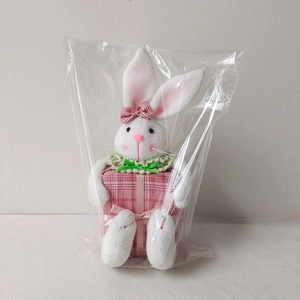 Detail of plush Easter bunny with pink plaid gift box in clear packaging