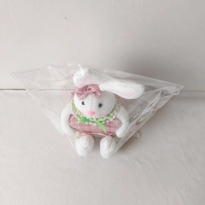 Detailed view of a white plush Easter bunny with a pink plaid bow holding a matching gift box