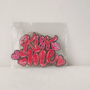 Detail of red hollow heart wooden hanging ornament with Kiss Me text for Valentine décor