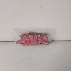 Detail of red Kiss Me wooden heart ornament for Valentine decoration in clear packaging