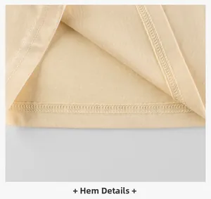 Detailed close-up of the double-stitched hem on a beige cotton girls' long sleeve t-shirt