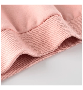 Detalle de sudadera de algodón rosa con dobladillo acanalado y textura de punto