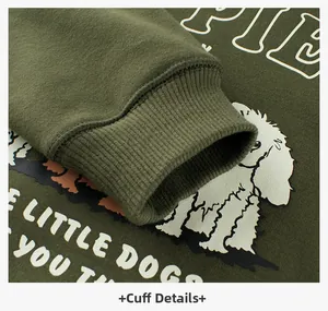 Close-up of green sweatshirt featuring ribbed cuff and cartoon little dog print detail