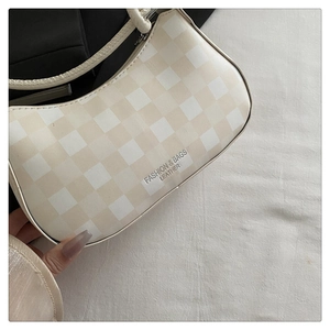 Nahaufnahme der karierten Hobo-Tasche mit Reißverschluss und modischem Logo-Detail