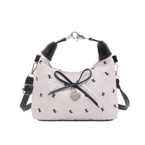 White quilted bow shoulder bag with black 'k' pattern and heart charm detail