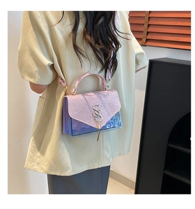 Détail du sac violet clair montrant le rabat pailleté, la texture PVC et le fermoir doré