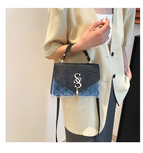 Detail of blue PVC crossbody bag with black sequin flap and silver double S buckle