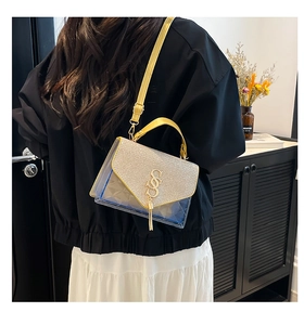 Détail du sac bandoulière en PVC bleu transparent avec paillettes dorées et pompon