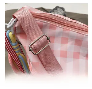 Close-up of pink and white checkered fabric bag with adjustable strap and metal buckle