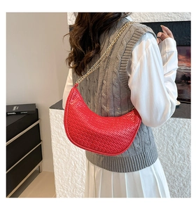 Vista dettagliata di una borsa a mezzaluna intrecciata rossa con elegante catena dorata