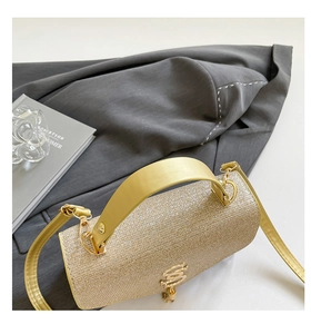 Détail du sac de soirée cylindrique doré champagne avec texture scintillante en strass