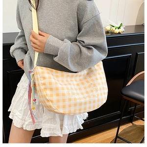 Detail of yellow gingham shoulder bag featuring cute bear print and textured strap