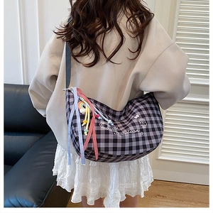 Detail of checkered crescent bag with cute heart bear embroidery and colorful ribbons