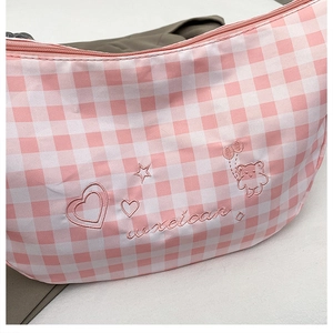 Detail of pink plaid bag featuring cute bear embroidery and heart star patterns