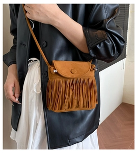 Detail der vintage kamelfarbenen Wildleder-Beuteltasche mit Fransen und Rundschnalle