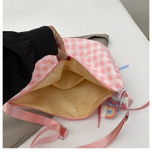 Interior detail of pink plaid crossbody bag showing spacious inner lining and zipper