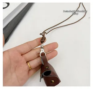 Detail van bruine leren mini-tas met afneembaar koord en metalen drukknopsluiting
