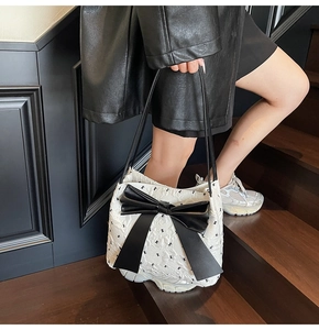 Détail du sac cabas matelassé avec nœud noir, imprimé ours et poignées en cuir
