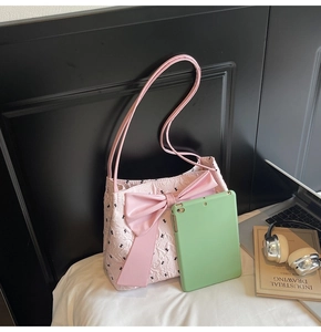 Détail du sac cabas matelassé rose avec motifs de nœuds noirs et grand nœud en satin