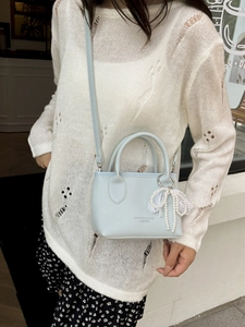 Light blue minimalist bucket bag with pearl lace charm and cross-body strap