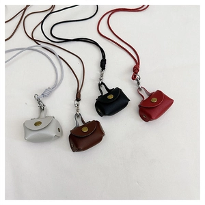 Gedetailleerd overzicht van mini leren oortelefoontasjes met retro metalen knopen in vier kleuren