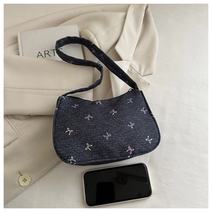Close-up of dark blue denim shoulder bag with colorful embroidered ribbon patterns