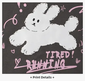 Detailed macro shot of white bunny print and pink text on dark grey fleece sweatshirt