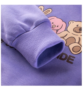 Detail of purple children hoodie showing ribbed cuffs and colorful cartoon animal prints