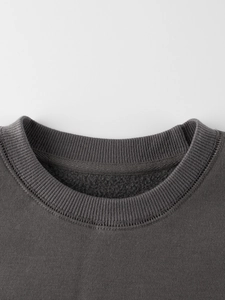 Close-up of deep grey crewneck sweatshirt with ribbed collar and double-stitched fleece lining