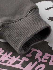 Close-up of dark grey hoodie with ribbed cuffs and soft purple printed lettering