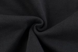 Close-up of premium black fleece knit fabric showing texture and soft draping for hoodies