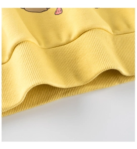 Macro shot of ribbed hem on yellow girl sweater showing knit fabric texture and elasticity