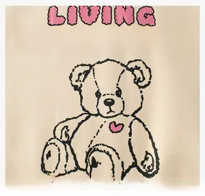 Detailed view of the cute teddy bear print and pink lettering on the cream sweatshirt