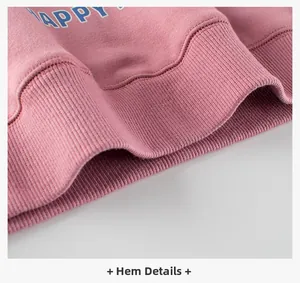 Detail of pink sweatshirt ribbed hem with blue HAPPY printed text on cotton fabric