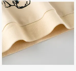 Detailed macro view of the ribbed hem and soft fabric of the beige children's sweatshirt