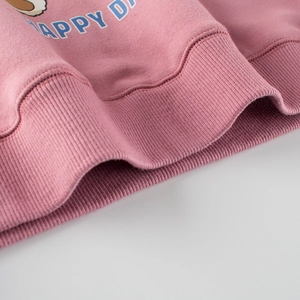 Close-up of ribbed cuffs and Happy D printing on pink knitted sweatshirt for kids