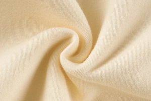 Close-up of soft cream knit fabric texture for children's sweatshirt and comfortable apparel