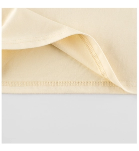 Close-up of double-needle stitching and overlock seams on beige cotton toddler t-shirt