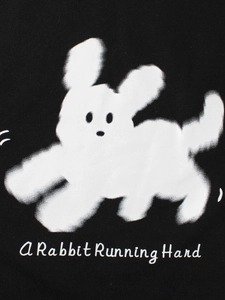 Vista frontal de sudadera negra infantil con conejo blanco peludo y texto impreso