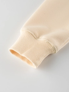 Detailed macro view of beige ribbed cuffs and knit fabric on a children hoodie