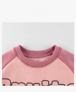 Détail du sweat en polaire rose montrant le col côtelé et la texture intérieure douce