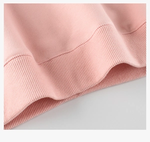 Détail du poignet en tricot côtelé du sweat-shirt rose avec coutures uniformes de qualité